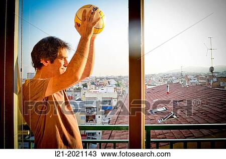 Man, with a ball, on a balcony. In the background, a cityscape. View Large Photo Image Stock Image - Man, with a ball, on a balcony. In the background, a cityscape.. Fotosearch