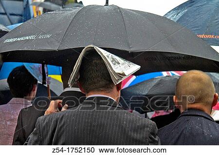 Stock Image - Man with a newspaper on head, London, England. Fotosearch