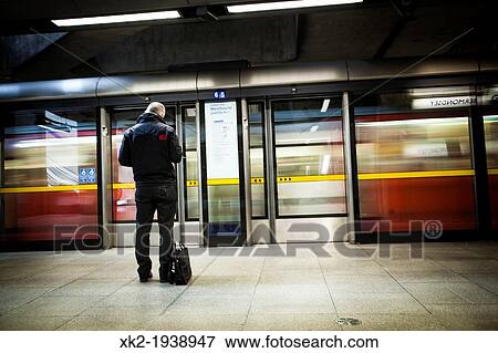 Man with a suitcase waiting for the underground in the jubilee line, Canary Wharf station, London, UK View Large Photo Image Stock Photo - Man with a suitcase waiting for the underground in the jubilee line, Canary Wharf station, London, UK. Fotosearch