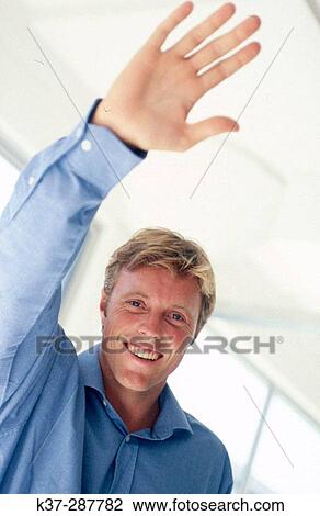 Man with arm raised giving high five View Large Photo Image Stock Image - Man with arm raised giving high five. Fotosearch