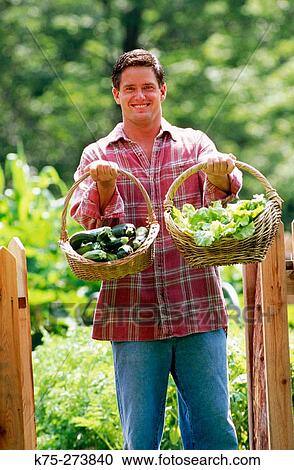 Man with baskets of vegetables View Large Photo Image Stock Image - Man with baskets of vegetables. Fotosearch