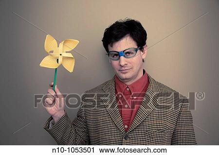 Stock Image - Man with broken glasses holding a pinwheel. Fotosearch