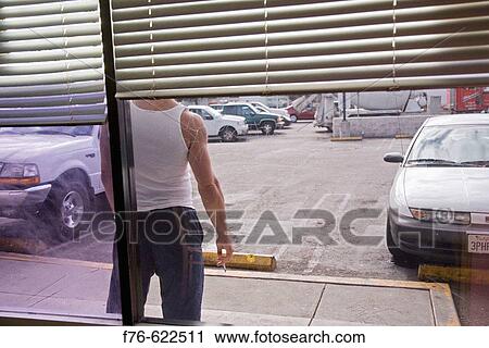 Man with cigarette waiting at parking lot. View Large Photo Image Stock Image - Man with cigarette waiting at parking lot.. Fotosearch