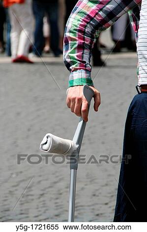 man with crutches in street road in city town View Large Photo Image Stock Photography - man with crutches in street road in city town. Fotosearch