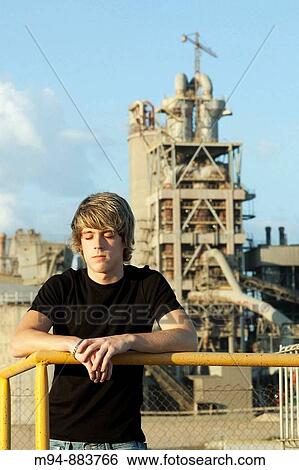 Stock Photograph - Man with eyes closed near a cement works. Fotosearch
