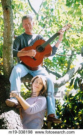 Stock Photo - man with guitar serranaiding a woman. Fotosearch