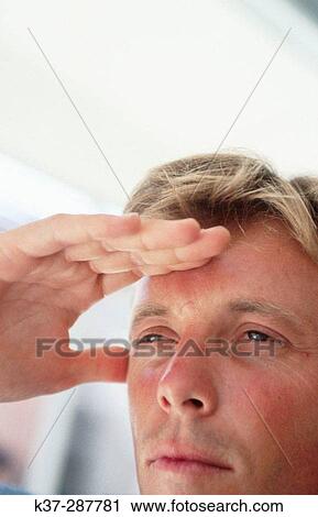 Man with hand on forehead looking into distance View Large Photo Image Stock Image - Man with hand on forehead looking into distance. Fotosearch