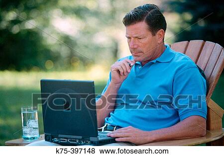 Stock Photo - Man with laptop outdoors. Fotosearch