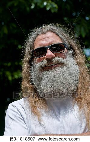 Stock Photo - Man with long hair and grey beard outdoors. Fotosearch