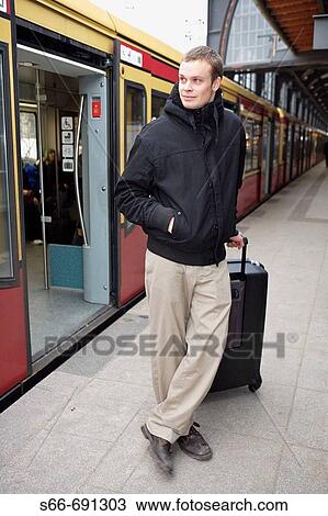 Stock Image - Man with luggage in front of a S Bahn car at Bahnhof Friedrichstrasse, Berlin, Germany. Fotosearch
