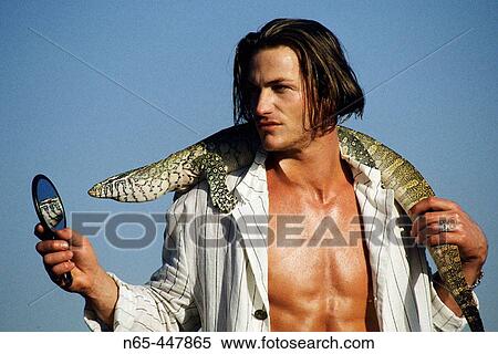 Stock Photography - Man with Monitor Lizard. Fotosearch