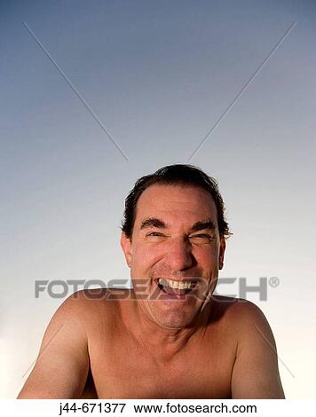 Stock Photo - Man with no shirt looking at camera laughing outdoors, Hollywood, Florida, USA. Fotosearch