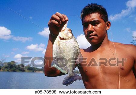 Stock Photo - Man with piranha. Orinoco. Vanezuela.. Fotosearch