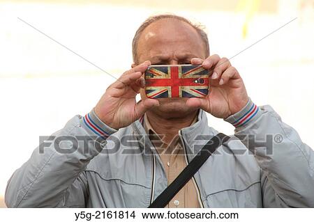 Picture - man with union jack flag cover on phone in rome italy. Fotosearch
