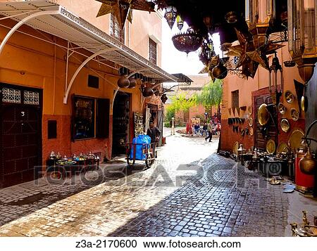 Man with waggon walking through a street with arabic shops in Marrakech, Morocco. View Large Photo Image Stock Image - Man with waggon walking through a street with arabic shops in Marrakech, Morocco.. Fotosearch