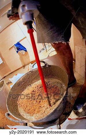 Stock Image - Man working in a bathroom.. Fotosearch