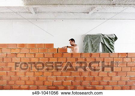 man working in a wall of bricks View Large Photo Image Stock Photograph - man working in a wall of bricks. Fotosearch
