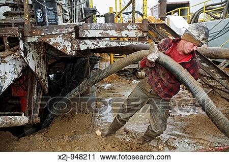 Mancelona, Michigan - A worker struggles with a hose while dismantling a natural gas drilling rig in the Antrim Shale field of northern Michigan View Large Photo Image Stock Image - Mancelona, Michigan - A worker struggles with a hose while dismantling a natural gas drilling rig in the Antrim Shale field of northern Michigan. Fotosearch