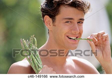 Mane eating asparagus View Large Photo Image Stock Photograph - Mane eating asparagus. Fotosearch