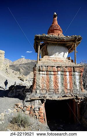 Stock Image - Mani wall (stones inscribed with a buddhist mantra) and stupa (chorten) in the village of Tangge. Nepal, Gandaki, Upper Mustang (near the border with Tibet). Model Released.. Fotosearch