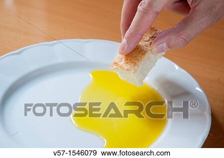Man's hand dipping bread in olive oil. Close view. View Large Photo Image Stock Photo - Man's hand dipping bread in olive oil. Close view.. Fotosearch