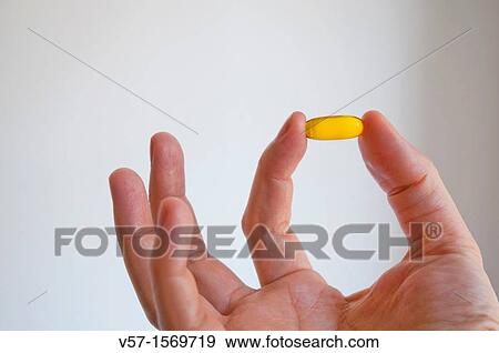 Man's hand holding a primrose pill. Close view. View Large Photo Image Stock Photo - Man's hand holding a primrose pill. Close view.. Fotosearch