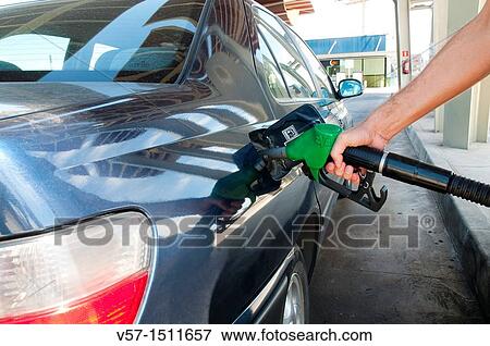 Man's hand holding gas pistol, refuelling at a gas station. Close view. View Large Photo Image Stock Photo - Man's hand holding gas pistol, refuelling at a gas station. Close view.. Fotosearch