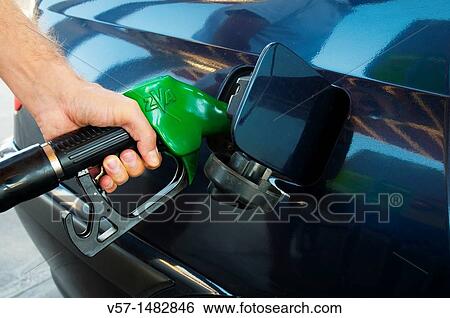 Man's hand holding gas pistol, refuelling at a gas station. Close view. View Large Photo Image Stock Photograph - Man's hand holding gas pistol, refuelling at a gas station. Close view.. Fotosearch