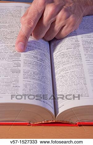 Man's hand looking up a word in the dictionary. Close view. View Large Photo Image Stock Image - Man's hand looking up a word in the dictionary. Close view.. Fotosearch