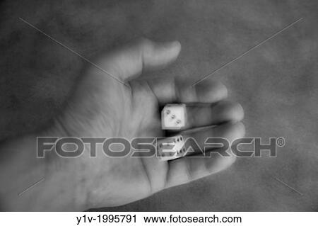 Stock Image - Man's hand shaking a pair of dice.. Fotosearch