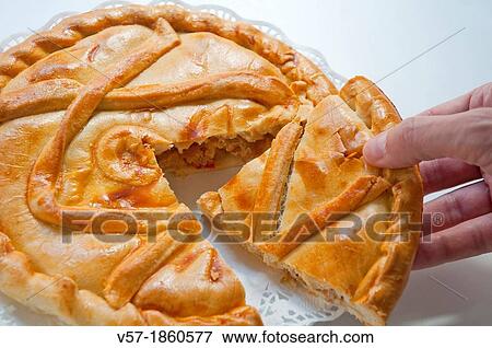 Stock Photo - Man's hand taking a piece of Spanish pie. Close view.. Fotosearch