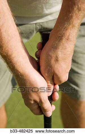Stock Photography - Man's hands gripping golf putter. Fotosearch