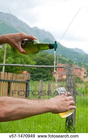 Stock Photo - Man's hands serving cider. Asturias, Spain.. Fotosearch