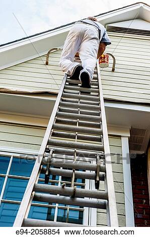 Man's legs climbing a ladder near the side of a house. View Large Photo Image Picture - Man's legs climbing a ladder near the side of a house.. Fotosearch