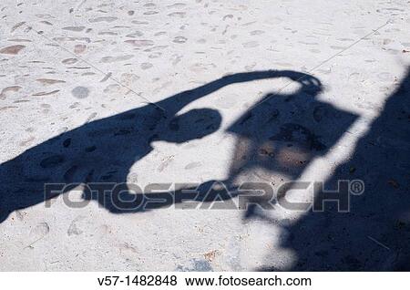 Man's shadow holding a street light shadow View Large Photo Image Stock Photo - Man's shadow holding a street light shadow. Fotosearch
