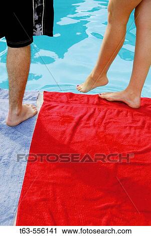 man/woman standing at edge of pool -woman dipping her foot in water View Large Photo Image Stock Image - man/woman standing at edge of pool -woman dipping her foot in water. Fotosearch