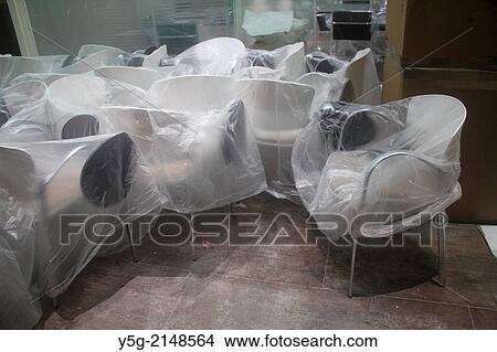 many new chairs covered with plastic sheets in office in rome italy View Large Photo Image Picture - many new chairs covered with plastic sheets in office in rome italy. Fotosearch