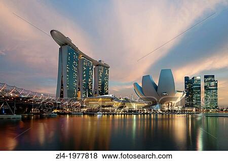Stock Photo - Marina Bay Sands hotel at sunset with the ArtScience museum designed by the architect Moshe Safdie, the helix bridge on the left. Singapore, Marina Bay.. Fotosearch
