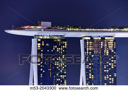 Stock Image - Marina Bay Sands Skypark at night. The SkyPark is a partially suspended rooftop deck, located on the top of Marina Bay Sands Hotel, that include a swimming pool, a bar, an obervation deck and a restaurant. Singapore.. Fotosearch