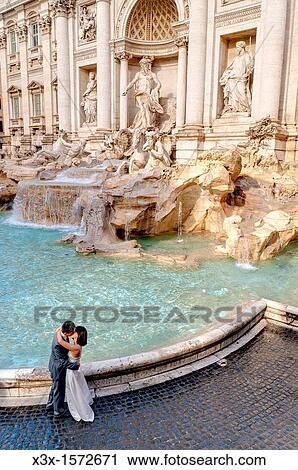 Stock Image - Married couple kissing by Fontana di Trevi in Rome Italy. Fotosearch