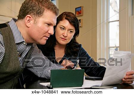 Married couple paying bills and going over their finances together View Large Photo Image Stock Image - Married couple paying bills and going over their finances together. Fotosearch