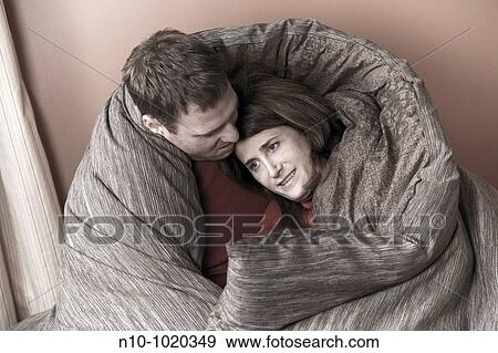 Married couple sitting on their bed View Large Photo Image Stock Photo - Married couple sitting on their bed. Fotosearch