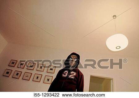 Stock Image - Masked man in a room. Fotosearch