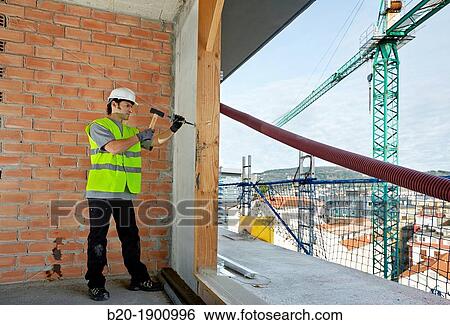 Mason by slashing the wall with hammer and chisel, Bricklayer with personal protective equipment, PPE, Apartment Building under construction, Donostia, San Sebastian, Gipuzkoa, Basque Country, Spain View Large Photo Image Stock Photograph - Mason by slashing the wall with hammer and chisel, Bricklayer with personal protective equipment, PPE, Apartment Building under construction, Donostia, San Sebastian, Gipuzkoa, Basque Country, Spain. Fotosearch