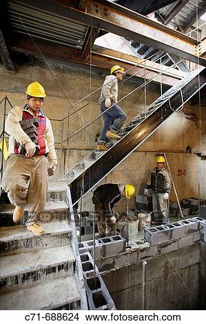 Picture - Masons building a block wall. Fotosearch