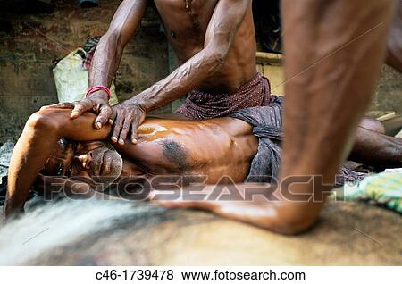 Masseurs give body massages to customers on a street, Kolkata, India, Ganges River. View Large Photo Image Stock Photo - Masseurs give body massages to customers on a street, Kolkata, India, Ganges River.. Fotosearch