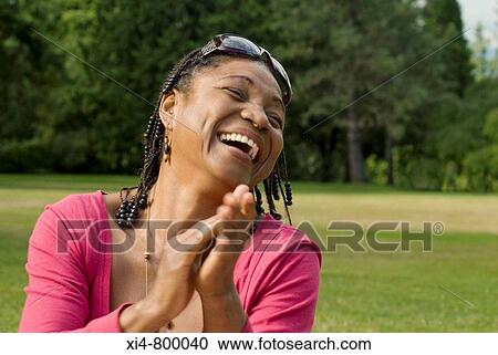 Mature African Hispanic woman clapping She is seated in the green grass and laughting View Large Photo Image Stock Image - Mature African Hispanic woman clapping She is seated in the green grass and laughting. Fotosearch