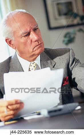 Mature businessman working on desk in an office View Large Photo Image Stock Photography - Mature businessman working on desk in an office. Fotosearch