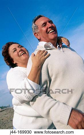 Mature couple enjoying at the beach View Large Photo Image Stock Image - Mature couple enjoying at the beach. Fotosearch