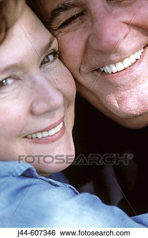 Stock Photograph - Mature couple hugging and smiling. Fotosearch
